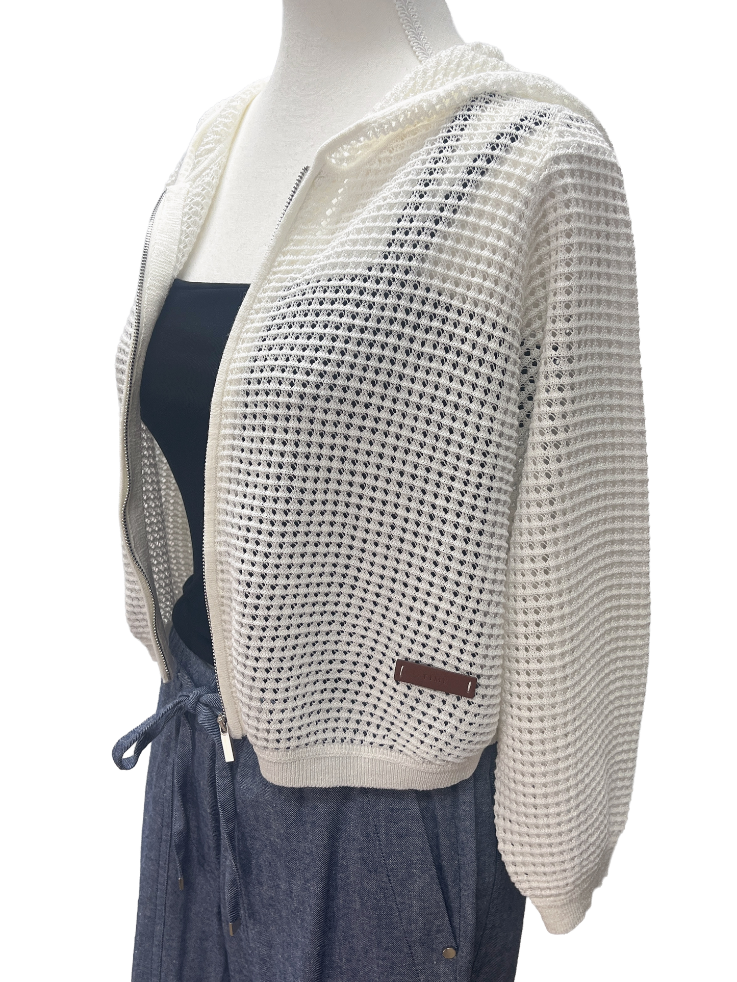 Mannequin wearing a white knit cardigan over a dark dress on a white background