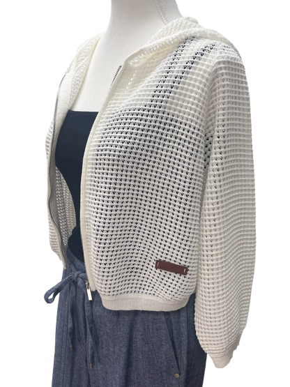 Mannequin wearing a white knit cardigan over a dark dress on a white background